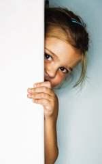 niña escondida detrás de una puerta