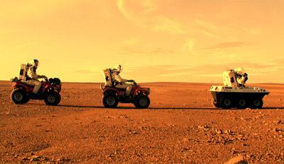 Primeros humanos explorando Marte en vehículos diseñados para moverse por la superficie yerma y rocosa