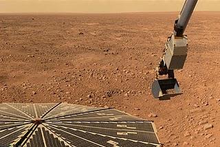 Fotografía de la sonda Phoenix, cargando suelo marciano en la pala de su brazo robótico