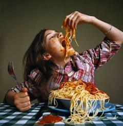 Girl eating spaghetti at table
