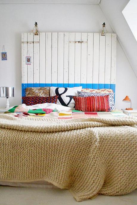Dormitorio, cabecero de tablillas de madera y mucho color en los textiles de la cama