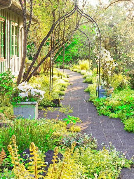 This path relies on elements close to the ground and overhead to create a sense of discovery.  -- Two streamlined metal arbors form an archway over the path, drawing the eye forward.