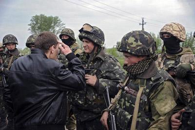 Vecinos increpan a algunos soldados ucranianos que permanecen en un puesto de control cercano a la ciudad de Slaviansk.
