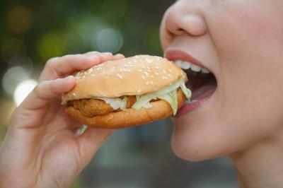 Mujer comiendo hamburguesa. Imagen: freedigitalphotos-tiverylucky