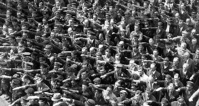 El hombre cruzado de brazos en medio del saludo nazi