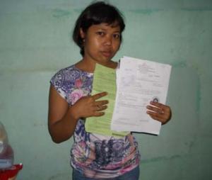 Una trabajadora doméstica indonesia sostiene el contrato engañoso por el que fue abusada en Hong Kong / Amnistía Internacional, Norma Kang Muico