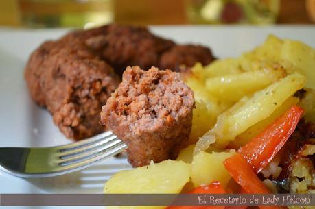 Rollitos de carne especiados acompañados de patatas y pimiento rojo