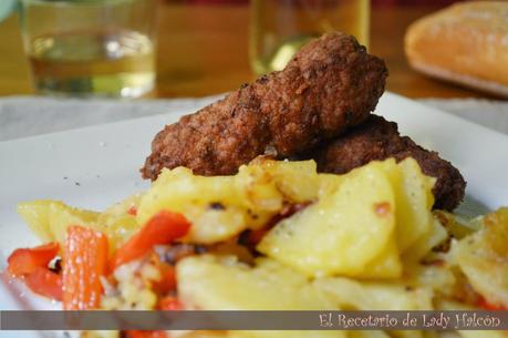 Rollitos de carne especiados acompañados de patatas y pimiento rojo