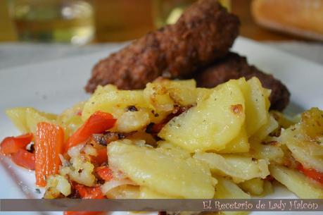 Rollitos de carne especiados acompañados de patatas y pimiento rojo