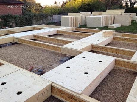 Se pueden ver anclajes al suelo, tirantes y unidades de madera semejantes a casetes Chasis de madera del piso de una vivienda en construcción con elementos sistematizados