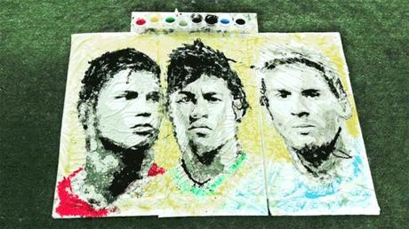 Una artista pinta varios retratos de futbolistas famosos con un balon y sus pies Una artista pinta varios retratos de futbolistas famosos con un balon y sus pies