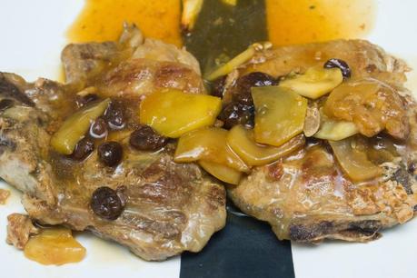 chuletas de cerdo con verduras y salsa de pasas y cava acompañadas de patatas fritas