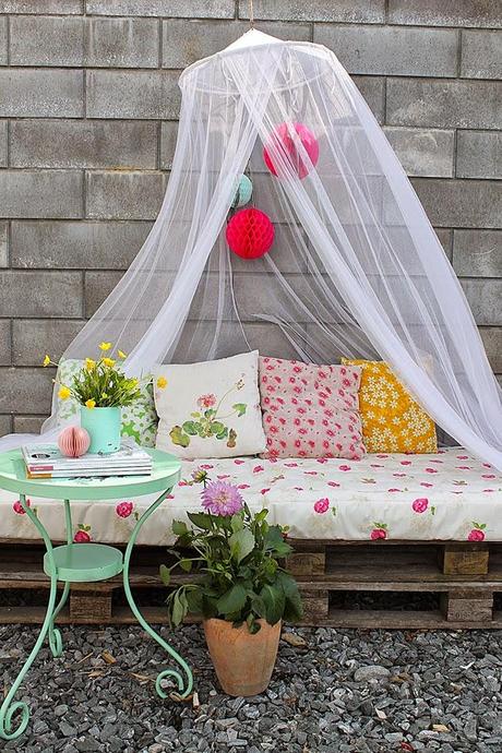 Un rincón en la  terraza con palets en tonos pastel