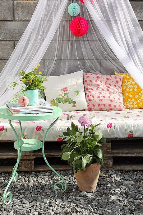 Un rincón en la  terraza con palets en tonos pastel