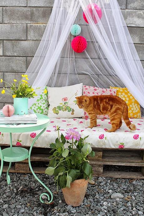 Un rincón en la  terraza con palets en tonos pastel