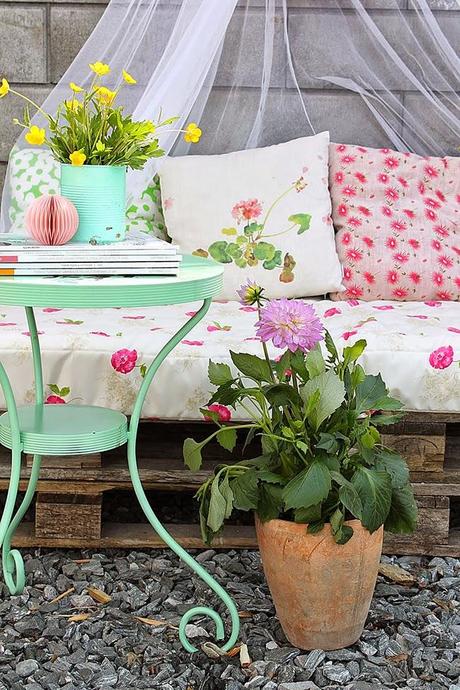 Un rincón en la  terraza con palets en tonos pastel