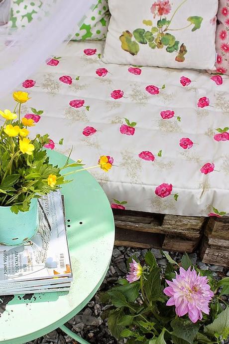 Un rincón en la  terraza con palets en tonos pastel