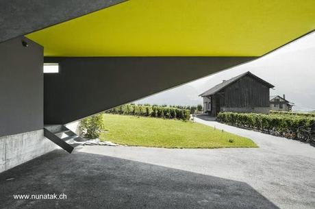 Espacio de cocheras y un acceso a casa 
contemporánea suiza