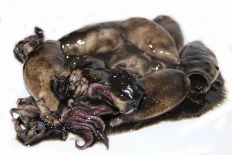 Arroz negro en paella (traditional black rice paella,  mediterranean style)