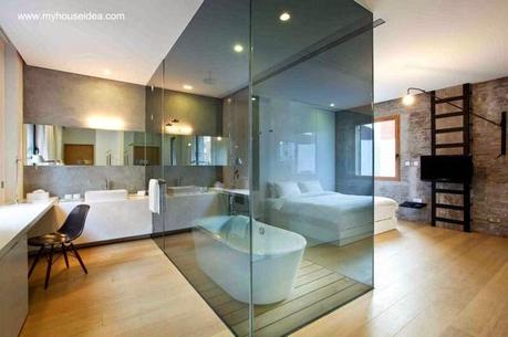 Bañera en una caja de cristal integrada al baño y dormitorio