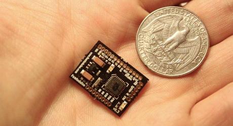 Femtoduino en la mano de una persona comparado con una moneda