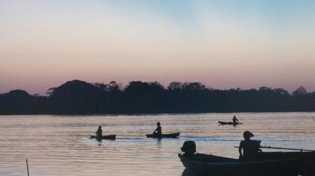Niños remando al atardecer en el Amazonas