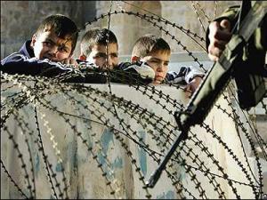 Niños en la valla de Gaza y al otro lado un militar israelí en el 2009. / AlphaBetaUnlimited