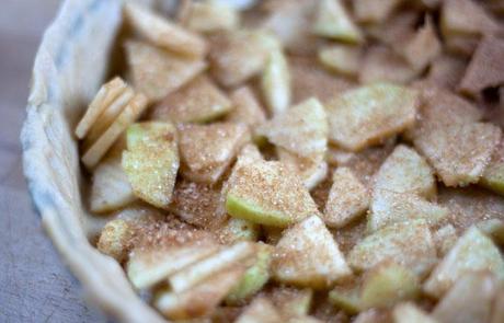 Manzanas troceadas con azúcar y canela en la tarta de mazana