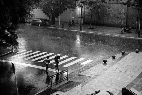Una pareja corre bajo una intensa lluvia, en Blanco y Negro