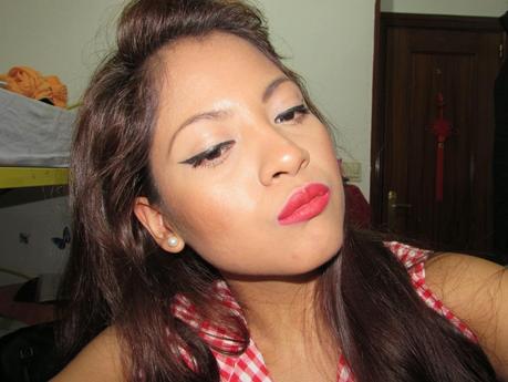 MAQUILLAJE CON DELINEADO NEGRO Y LABIOS DE COLOR ROJO.