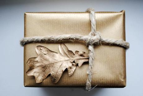 Envoltorio de regalo con hojas secas pintadas de dorado