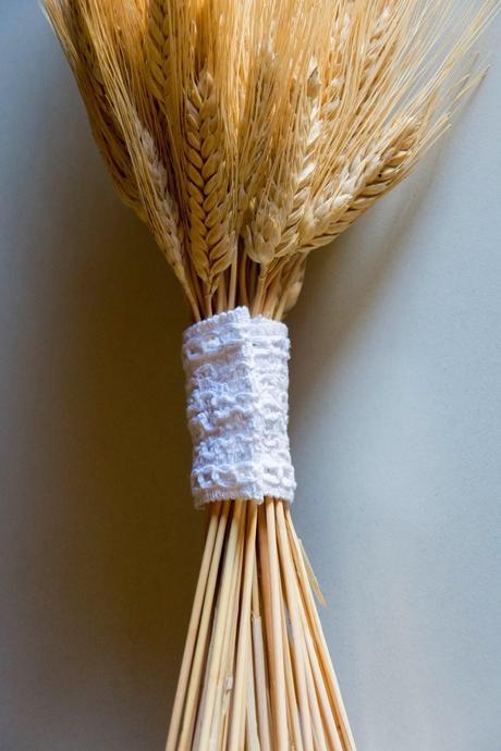 puño de encaje sobre ramo de espigas