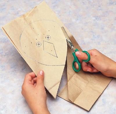 Trace the bird kite's body onto the paper bag and cut out.