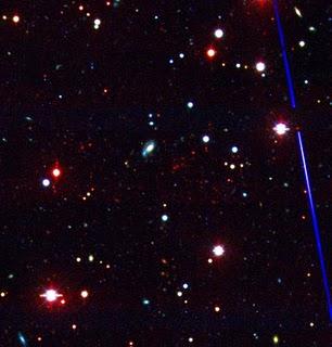 Esta imagen óptica del cúmulo de galaxias recién descubierto pone de relieve el enrojecimiento de estas galaxias debido a su gran distancia