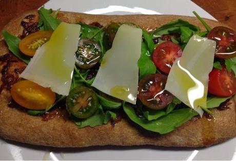 Coca integral con rúcula y tomates cherry.