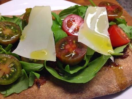 Coca integral con rúcula y tomates cherry.