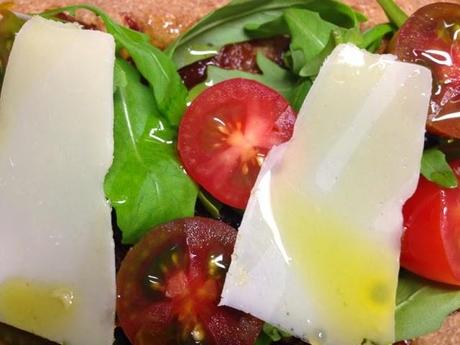 Coca integral con rúcula y tomates cherry.