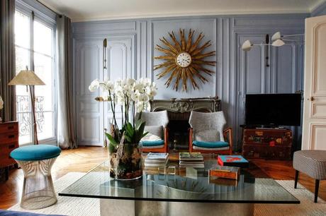 Un salón con un gran espejo sol convertido en reloj