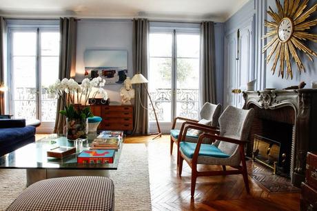 Un salón con un gran espejo sol convertido en reloj