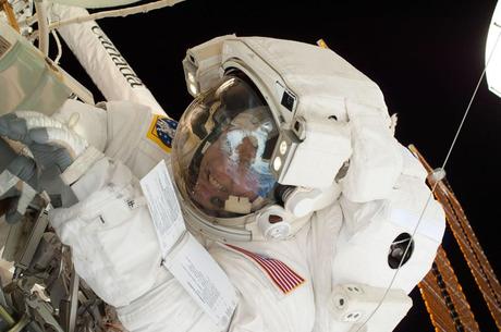 A look into the helmet visor of this astronaut on a spacewalk reveals the easily recognizable smiling countenance of NASA astronaut Michael Fincke