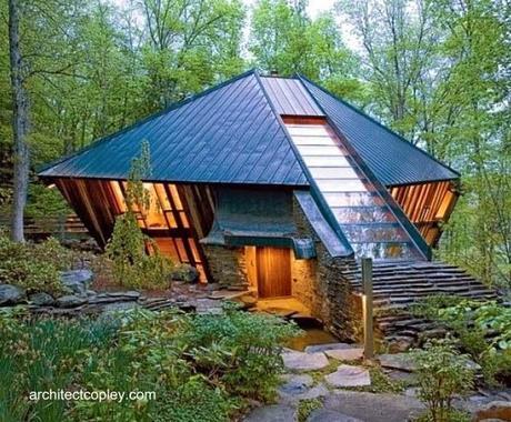 Casa rústica en un claro de bosque tiene forma de diamante tallado Cabaña de madera y piedra con diseño orgánico en Estados Unidos