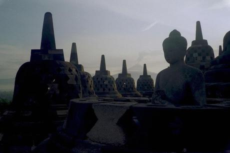 Mt. Merapi erupts from Borobudur with Buddha statue in foreground