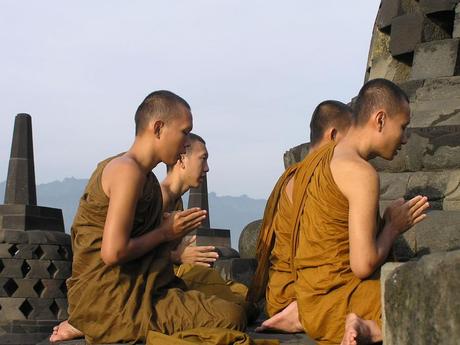 Buddhist pilgrims meditate on the top platform at Borobudur