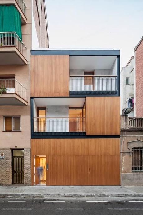 Entre dos bloques, una vivienda diseñada hacia el interior donde la madera es protagonista