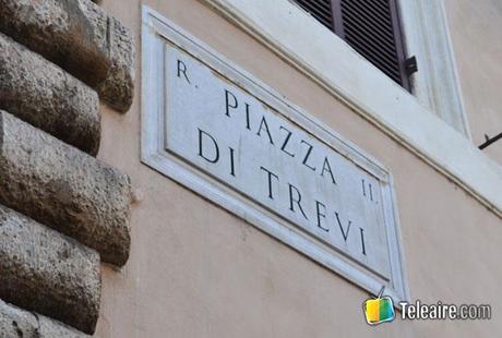 cartel de la piazza di trevi junto a la fontana