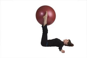 Ejercicio de doblar las piernas con bola grande Ejercicio de doblar las piernas con bola grande