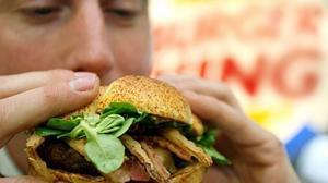 Hombre comiendo una hamburguesa