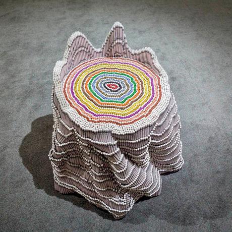 Escultura de tronco de árbol creada con crayons de colores por Herb Williams