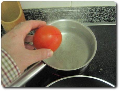Cuando el agua hierva, echamos dentro los tomates. Los tendemos ahí 1 minuto, aproximadamente.