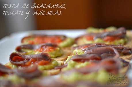 Tosta de guacamole, tomate y anchoas.